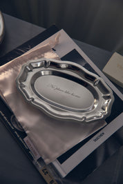 Silver decorative tray on a book with 'No place like home' text